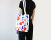 Cherry Art Bag, handmade tote designed by Auracherrybag. White with cherry pattern. Modelled by person in black